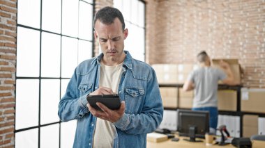 Ofiste çalışan iki işçi touchpad kullanıyor.