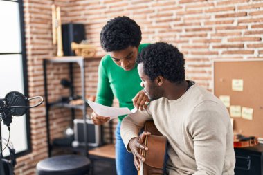 Afrika kökenli Amerikalı erkek ve kadın müzik grubu müzik stüdyosunda beste yapıyor.