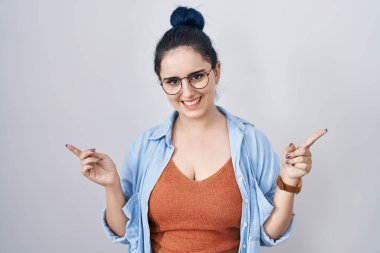 Beyaz arka planda duran mavi saçlı, kendine güvenen, farklı yönleri gösteren genç, modern bir kız. reklam için kopyalama alanı 