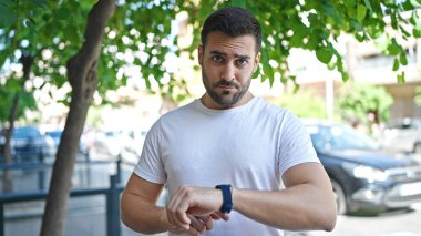 Sokakta gevşemiş bir ifadeye sahip İspanyol bir adam arıyor.