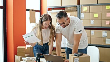 Genç kadın ve erkek ecommerce üzerinde çalışıyor.