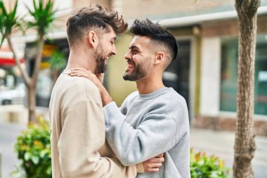 Young couple smiling confident hugging each other at street