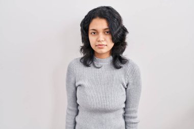 Tecrit edilmiş arka planda duran koyu renk saçlı İspanyol kadın yüzünde ciddi bir ifadeyle rahatlamış. Basit ve doğal bir şekilde kameraya bakıyorsun.. 