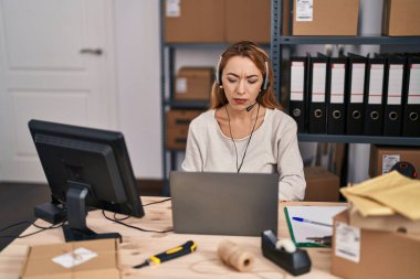Küçük işletmelerde çalışan İspanyol bir kadın. Kulaklık takıyor. Düşünme tavrı takıyor. 