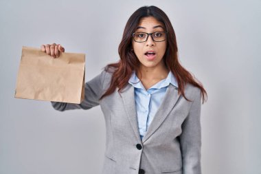 Paket tutan İspanyol genç kadın korkmuş ve hayrete düşmüş ağzı açık, şaşırmış, inançsız yüz. 