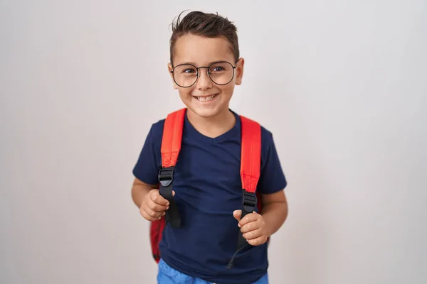 眼鏡と学生のバックパックを身に着けている小さなヒスパニック系の男の子はポジティブで幸せな立っていると歯を示す自信を持って笑顔で笑顔 — ストック写真