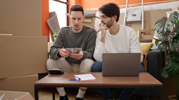 Двоє Чоловіків Використовують Ноутбук Рахуючи Долари Новому Будинку — стокове фото