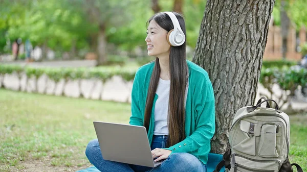 Νεαρή Κινέζα Γυναίκα Που Χρησιμοποιεί Φορητό Υπολογιστή Και Ακουστικά Κάθεται — Φωτογραφία Αρχείου