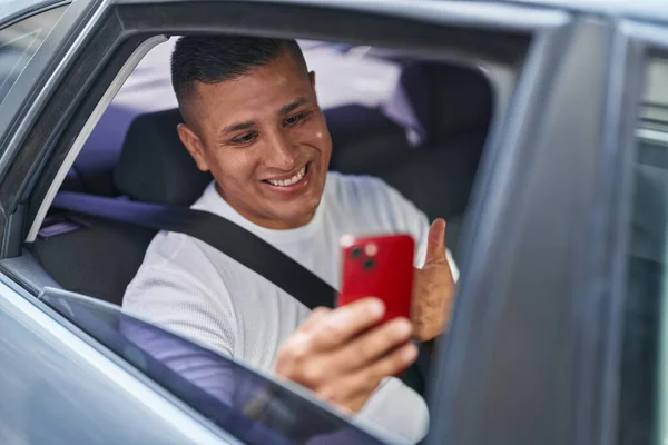 年轻的他的惊慌失措的男人用智能手机在车里做视频通话 面带微笑 面带微笑 大拇指向上做得很出色 签了字 — 图库照片
