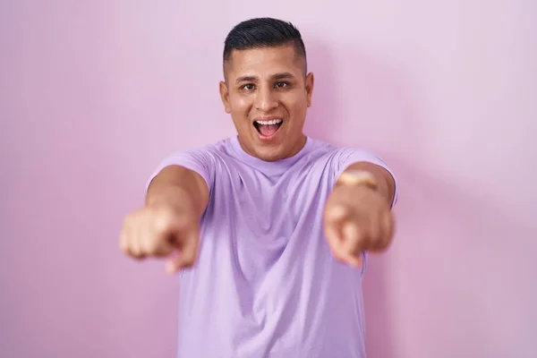 Молодой Латиноамериканец Стоящий Розовом Фоне Указывая Тебя Камеру Пальцами Улыбаясь — стоковое фото
