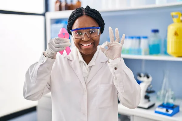 과학자 실험실에서 일하는 아프리카 미국인 분홍색 리본을 손가락으로 보이는 사인을 — 스톡 사진
