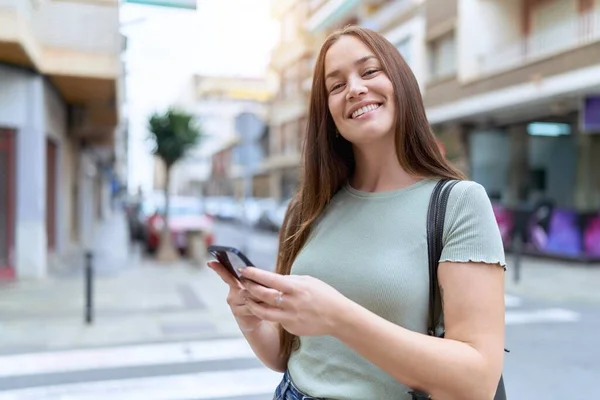 若い美しい女性笑顔自信を持って使用してスマートフォンでストリート — ストック写真