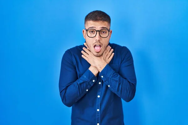 Mavi Arka Planda Gözlük Takan Spanyol Genç Adam Bağırıyor Boğuluyor — Stok fotoğraf