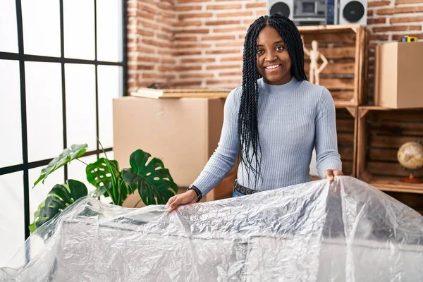 Αφροαμερικανή Γυναίκα Χαμογελώντας Αυτοπεποίθηση Καλύπτει Καναπέ Πλαστικό Στο Νέο Σπίτι — Φωτογραφία Αρχείου