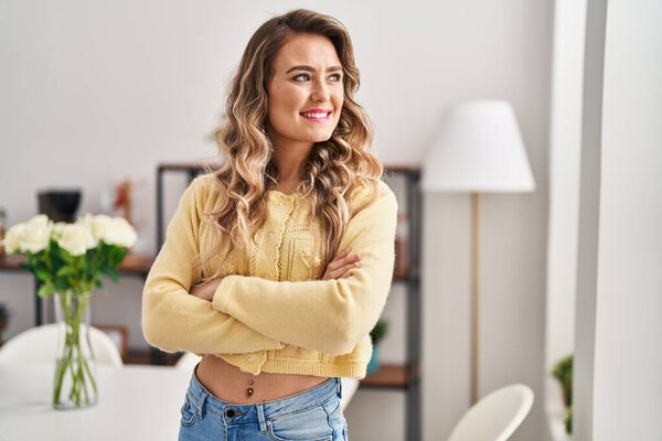 Young woman smiling confident standing with arms crossed gesture at home