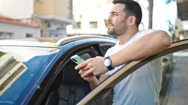 Young Hispanic Man Using Smartphone Leaning Car Street — Stok fotoğraf