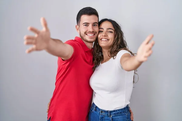 Genç Spanyol Çift Izole Edilmiş Arka Planda Kameraya Bakıp Kucaklaşmak — Stok fotoğraf