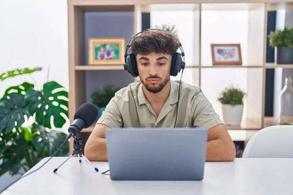 stock image Arab man with beard working at the radio with serious expression on face. simple and natural looking at the camera. 