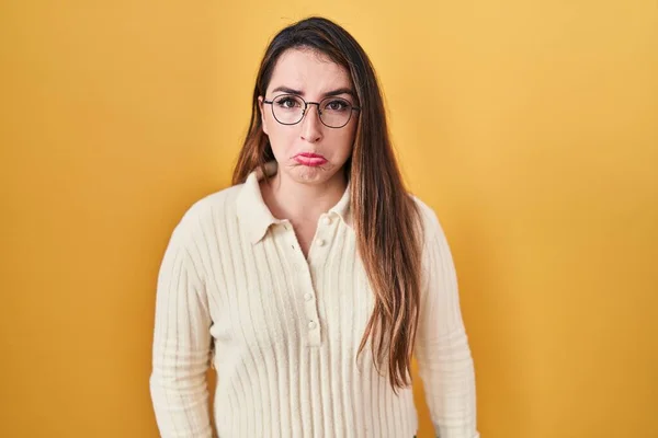 若いヒスパニック系の女性が黄色の背景の上に立って落ち込んで苦痛を心配し 怒っていると恐れて泣く 悲しい表情 — ストック写真