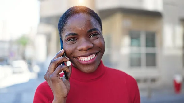 在街上笑着用智能手机说话的非裔美国女人 — 图库照片