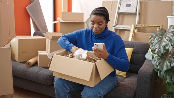 Африканская Американка Распаковывает Картонную Коробку Смартфона Новом Доме — стоковое фото