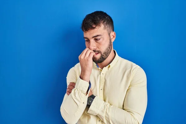 Bonito Homem Hispânico Sobre Fundo Azul Olhando Estressado Nervoso Com — Fotografia de Stock