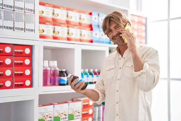 年轻顾客在药店用智能手机拿着药瓶聊天 — 图库照片