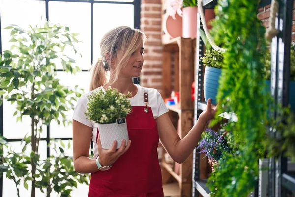 Jovem Mulher Loira Florista Sorrindo Confiante Segurando Planta Florista — Fotografia de Stock
