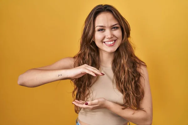 Young Hispanic Woman Standing Yellow Background Gesturing Hands Showing Big —  Fotos de Stock