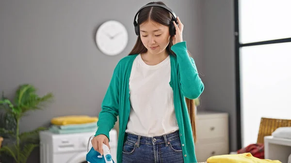 Młoda Chinka Słuchająca Muzyki Prasowanie Ubrań Pralni — Zdjęcie stockowe