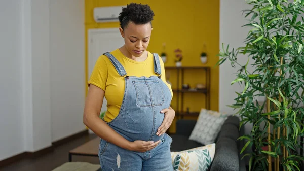 Jonge Zwangere Vrouw Aanraken Buik Met Ontspannen Uitdrukking Thuis — Stockfoto