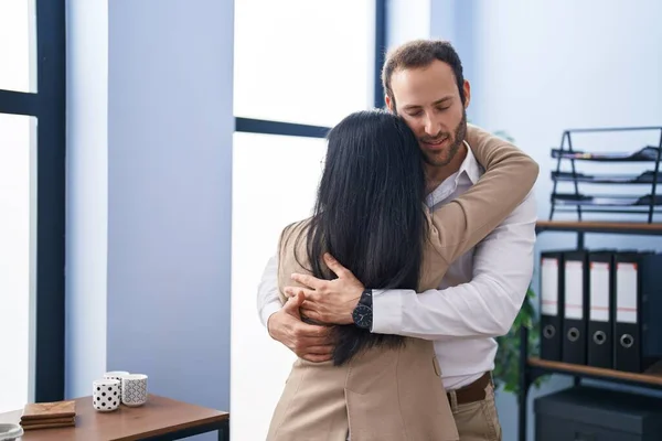 stock image Man and woman business workers hugging each other standing at office