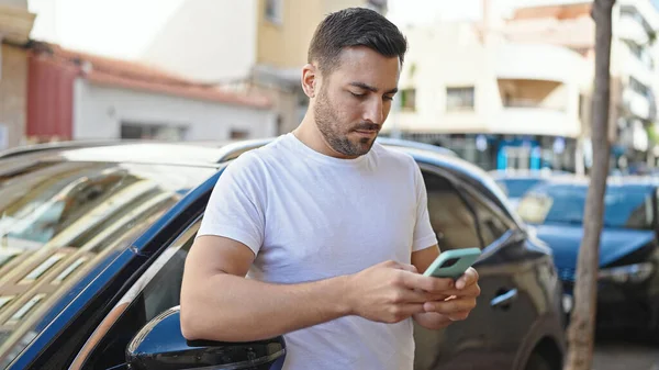 Young Hispanic Man Using Smartphone Leaning Car Street —  Fotos de Stock