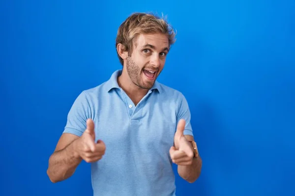 白人男子站在蓝色的背景上 手指指向镜头 脸上洋溢着欢乐和滑稽的表情 充沛的精力和活力 — 图库照片