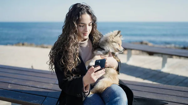 Junge Hispanische Frau Mit Hund Sitzt Mit Smartphone Auf Bank — Stockfoto
