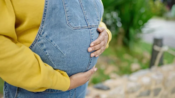 若いです妊娠女性タッチ腹で公園 — ストック写真