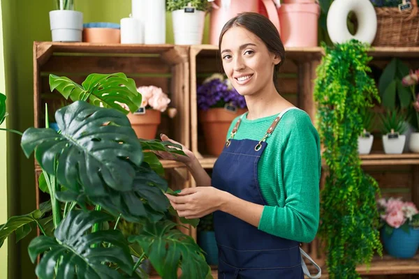 Çiçekçide kendine güvenen güzel İspanyol kadın çiçekçi.
