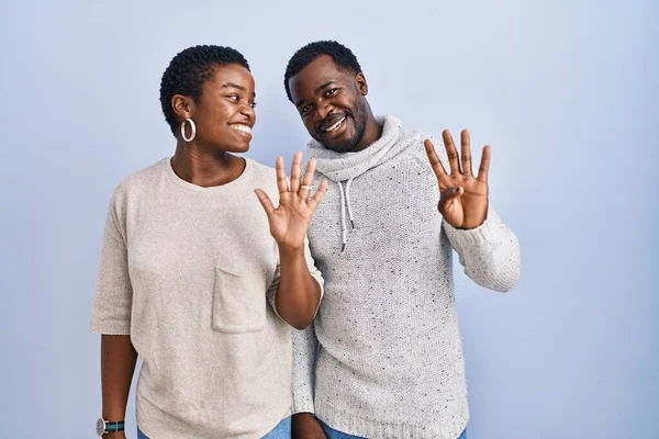 Молодая Африканская Американская Пара Стоящая Синем Фоне Вместе Показывающая Пальцами — стоковое фото