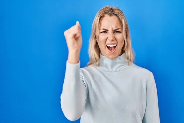 Young Caucasian Woman Standing Blue Background Angry Mad Raising Fist — Zdjęcie stockowe