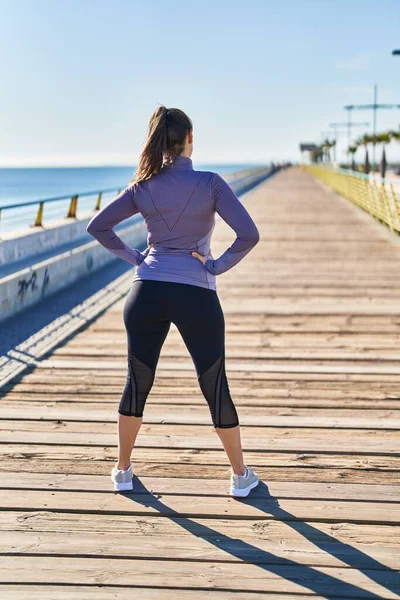 Young Beautiful Hispanic Woman Wearing Sportswear Standing Back View Seaside — Stockfoto