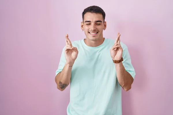 Handsome Hispanic Man Standing Pink Background Gesturing Finger Crossed Smiling — Stock Photo, Image