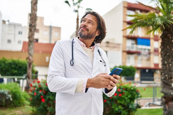 Médico Hombre Mediana Edad Sonriendo Confiado Usando Teléfono Inteligente Parque —  Fotos de Stock