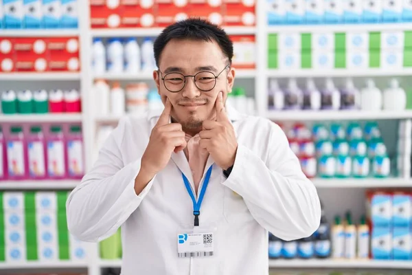 Čínský Mladík Pracující Lékárně Usmívá Otevřenými Ústy Prsty Ukazuje Nutí — Stock fotografie