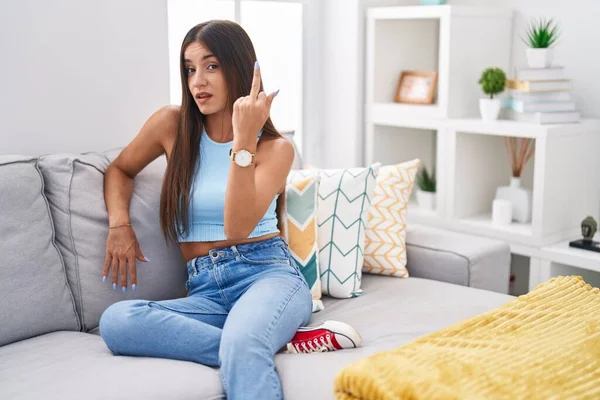 Young Brunette Woman Sitting Sofa Home Showing Middle Finger Impolite — Stockfoto