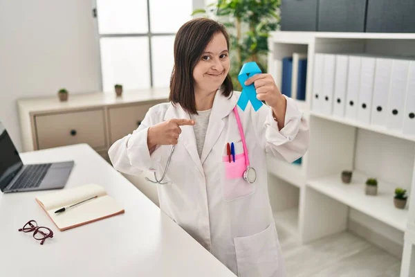 Ισπανόφωνη Κοπέλα Σύνδρομο Φορώντας Στολή Γιατρού Κρατώντας Μπλε Κορδέλα Χαμογελώντας — Φωτογραφία Αρχείου