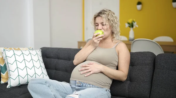 Jonge Zwangere Vrouw Eten Appel Aanraken Buik Thuis — Stockfoto