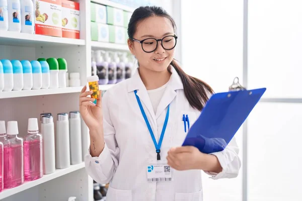 Ung Kinesisk Kvinna Farmaceut Håller Piller Flaska Läsa Dokument Apoteket — Stockfoto