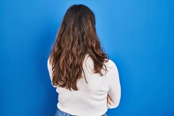 Genç Spanyol Kadın Mavi Arka Planda Dikiliyor Arkaya Bakıyor Kollarını — Stok fotoğraf
