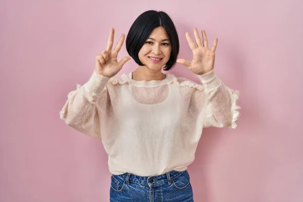 Jonge Aziatische Vrouw Staande Roze Achtergrond Tonen Wijzen Met Vingers — Stockfoto