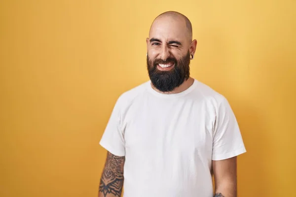 Jonge Spaanse Man Met Baard Tatoeages Gele Achtergrond Knipogen Naar — Stockfoto